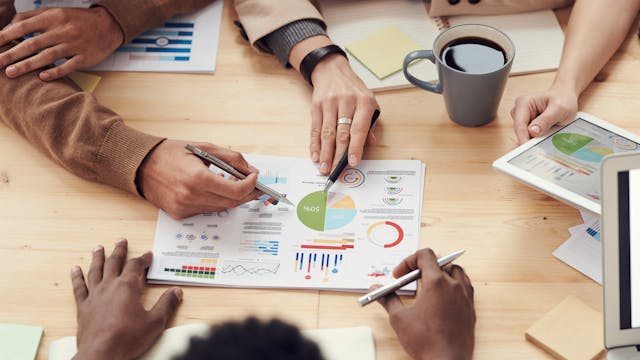 People pointing at a budget report on a table